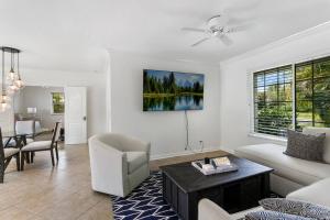 ein Wohnzimmer mit einem Sofa und einem Tisch in der Unterkunft Tropical Oasis - Heated Pool - 4 BE/2BA- 8 beds in North Palm Beach