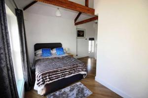 a bedroom with a bed with blue pillows on it at Boutique Apartment Brixham in Brixham