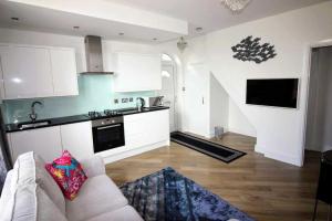 een woonkamer met een bank en een keuken bij Boutique Apartment Brixham in Brixham