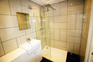 a white bathroom with a sink and a shower at Boutique Apartment Brixham in Brixham