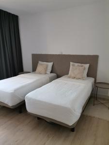 two beds sitting next to each other in a room at Apartamento Playa Las Americas in Playa de las Americas +9 photos