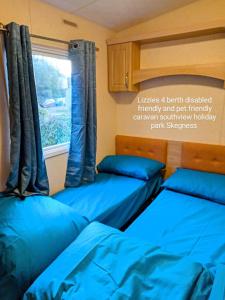 two beds in a room with a window at Southview holiday park skegness disabled friendly in Skegness