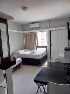 a hotel room with two beds and a table at Flat na praia de iracema,vista mar 606 in Fortaleza