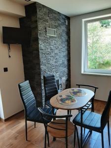 a room with a table and chairs and a fireplace at Czarny Potok Domki całoroczne in Czarna