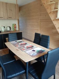 a wooden table with four chairs around it at Czarny Potok Domki całoroczne in Czarna