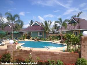 a swimming pool in front of a house at Coconut Homes Khao Lak in Khao Lak