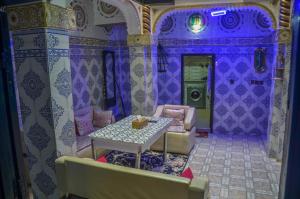 ein lila Zimmer mit einem Tisch und Stühlen in der Unterkunft LA casa Dar Rayan in Fès