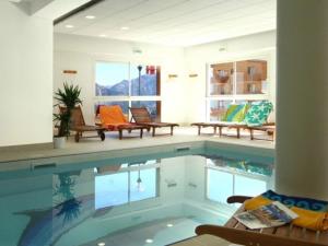 una piscina in una stanza con panche e sedie di Appartement Puy-Saint-Vincent, 2 pièces, 6 personnes - FR-1-330G-76 a Puy-Saint-Vincent