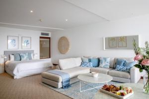 a living room with a couch and a table at Beach Suites in Byron Bay