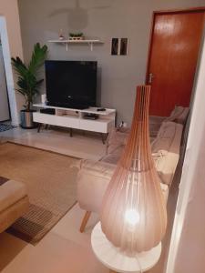 a living room with a couch and a television at Lindo Flat em Maresias in São Sebastião