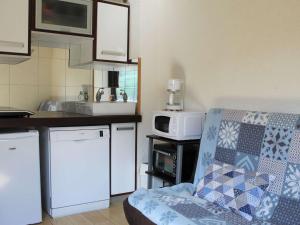 a small kitchen with a couch and a microwave at Appartement Vars, 1 pièce, 2 personnes - FR-1-330B-149 in Vars