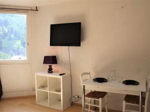 a living room with a table and a television on a wall at Appartement Vars, 1 pièce, 2 personnes - FR-1-330B-149 in Vars