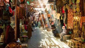a street in a market with people sitting in the aisle at Appartement meublé in Fez
