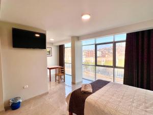 um quarto de hotel com uma cama e uma grande janela em HOTEL DORADO AREQUIPA em La Apacheta
