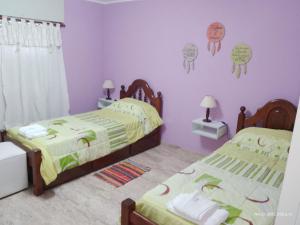 2 camas en un dormitorio con paredes moradas en Mí cielo en Huerta Grande