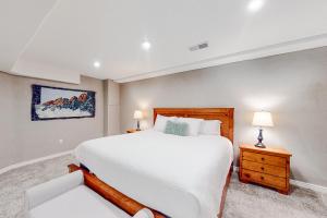 a bedroom with a large white bed and two lamps at Stone Creek Fairway in Avon