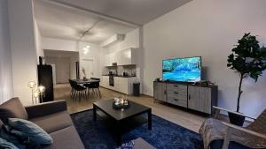 een woonkamer met een bank en een flatscreen-tv bij OneLuxStay near Fashion District in Antwerpen
