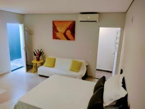 a living room with two beds and a couch at Flat Ideal Guarujá - Apto Studio Mobiliado, Ar-Condic e Cozinha Completa in Guarujá