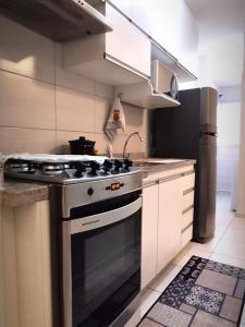 a kitchen with a stove and a refrigerator at Aconchego Poços de Caldas in Poços de Caldas