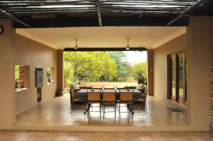 - une salle à manger avec une table et des chaises dans l'établissement Ukutula Lion Lodge, à Brits