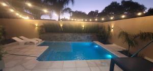 uma pequena piscina com luzes num pátio em La Quinta Apart em Cruz del Eje
