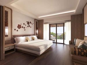 a bedroom with a large white bed and a couch at Novotel Bogor Golf Resort in Bogor