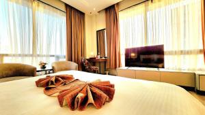 Cette chambre comprend un grand lit et une serviette. dans l'établissement Best Western Premier Hotel Gulberg Lahore, à Lahore