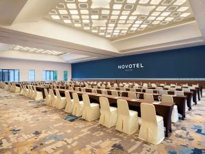 een grote kamer met rijen tafels en stoelen bij Novotel Bogor Golf Resort in Bogor