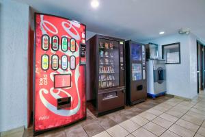 una máquina expendedora de coca cola junto a una máquina de refrescos en Motel 6-Jackson, MS, en Jackson