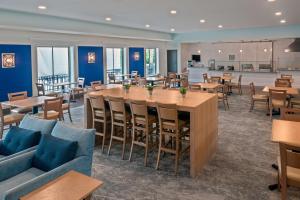 un restaurante con paredes azules, mesas y sillas en Ameniti Bay - Best Western Signature Collection en Sarasota