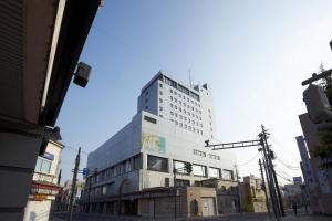 un edificio blanco alto en una calle de la ciudad en Hirosaki Park Hotel, en Hirosaki