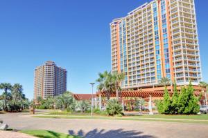 two tall buildings with palm trees in a park at Portofino Island Resort & Spa 1-2003 in Pensacola Beach