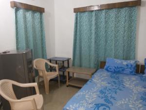 カンドリムにあるJason Guest Houseのベッドとテーブルと椅子のある寝室