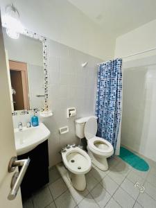 a bathroom with a toilet and a sink and a shower at San Luis Apartment in San Luis