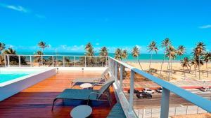 uma varanda com cadeiras e vista para a praia em Puerto Ventura Cabo Branco Beira-mar Genius Flats em João Pessoa