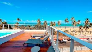 a balcony with chairs and a view of the beach at Puerto Ventura Cabo Branco Beira-mar Genius Flats in João Pessoa