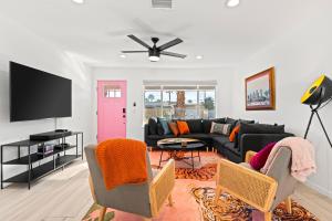 a living room with a black couch and a pink door at La Vie en Rose Permit# 3901 in Palm Springs