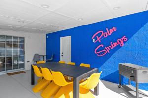 a dining room with a table and yellow chairs at La Vie en Rose Permit# 3901 in Palm Springs +30 photos