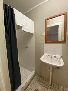 a bathroom with a sink and a shower with a mirror at Tiona Holiday Park in Tiona