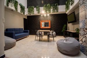 a living room with a blue couch and a table at Mándala Hotel Belén in Medellín