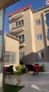 ein Gebäude mit Tischen und Stühlen davor in der Unterkunft Hotel Hayatt NX in Nouakchott