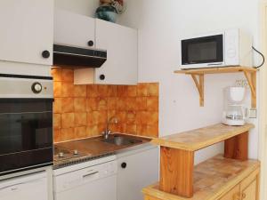 una pequeña cocina con fregadero y microondas en Appartement Vars, 1 pièce, 6 personnes - FR-1-330B-106, en Vars