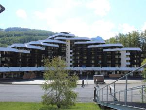 un gran edificio frente a un aparcamiento en Appartement Vars, 1 pièce, 6 personnes - FR-1-330B-106, en Vars