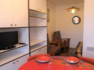 ein Esszimmer mit einem Tisch und einem TV sowie ein Wohnzimmer in der Unterkunft Appartement Vars, 2 pièces, 5 personnes - FR-1-330B-105 in Vars