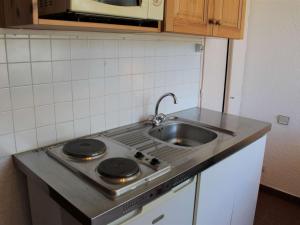 een keuken met een wastafel en een fornuis top oven bij Appartement Vars, 1 pièce, 2 personnes - FR-1-330B-111 in Vars