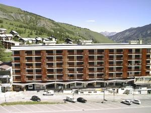 a large building with cars parked in a parking lot at Appartement Vars, 1 pièce, 2 personnes - FR-1-330B-111 in Vars