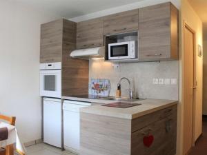 een kleine keuken met een wastafel en een magnetron bij Appartement Vars, 1 pièce, 4 personnes - FR-1-330B-121 in Vars