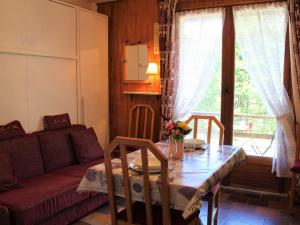 a living room with a table and a couch at Appartement Vars, 1 pièce, 3 personnes - FR-1-330B-127 in Vars