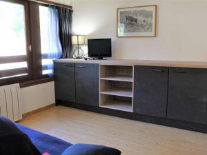 a living room with a desk with a tv on it at Appartement Vars, 2 pièces, 4 personnes - FR-1-330B-129 in Vars