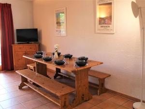 a wooden table with bowls on it with a bench at Appartement Vars, 5 pièces, 10 personnes - FR-1-330B-139 in Vars